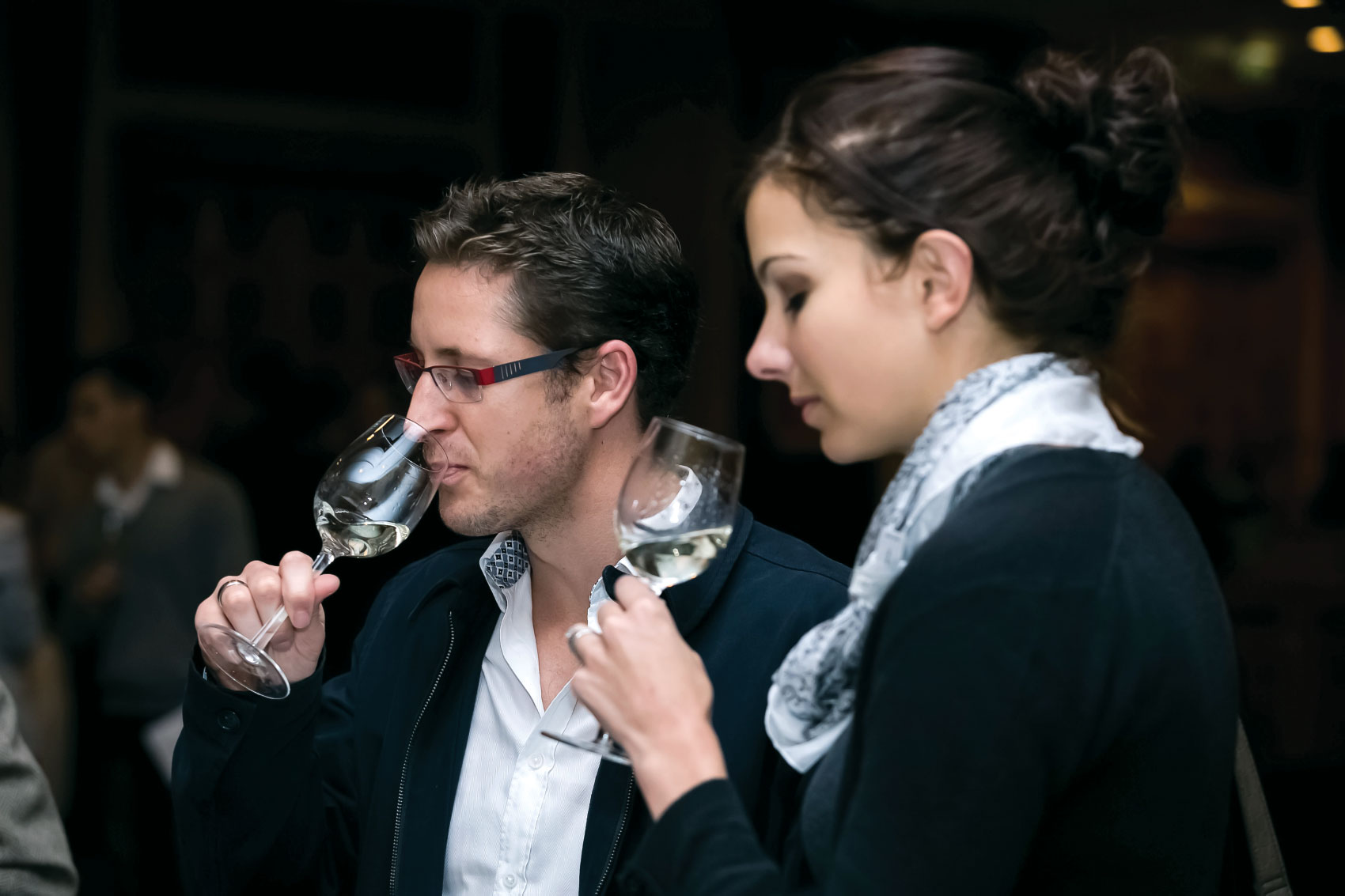 Man and woman sampling white wine