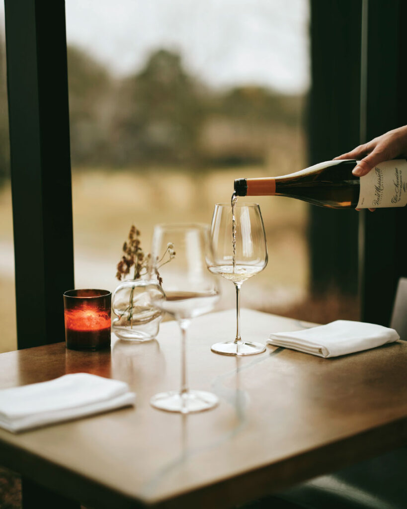 Pouring wine from bottle in glasse