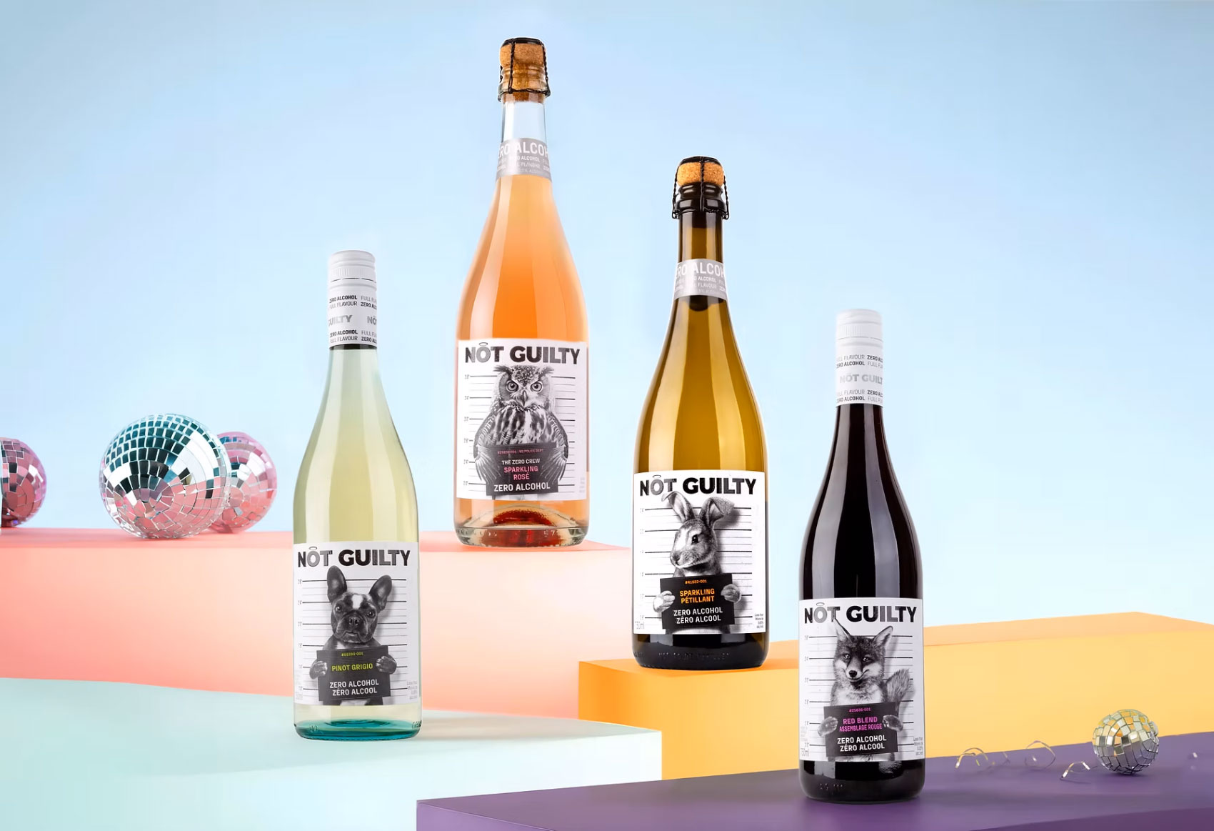 Four bottles of Not Guilty wine on pastel-coloured box stands