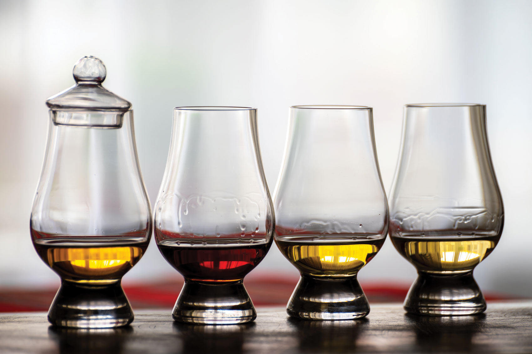 Four snifter glasses of various alcohols