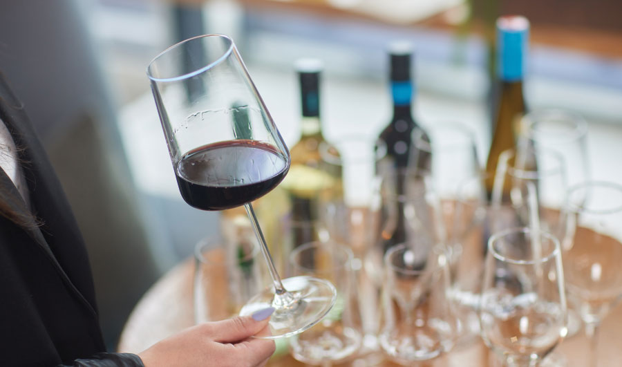 Glass of wine with wine glasses and bottles in background