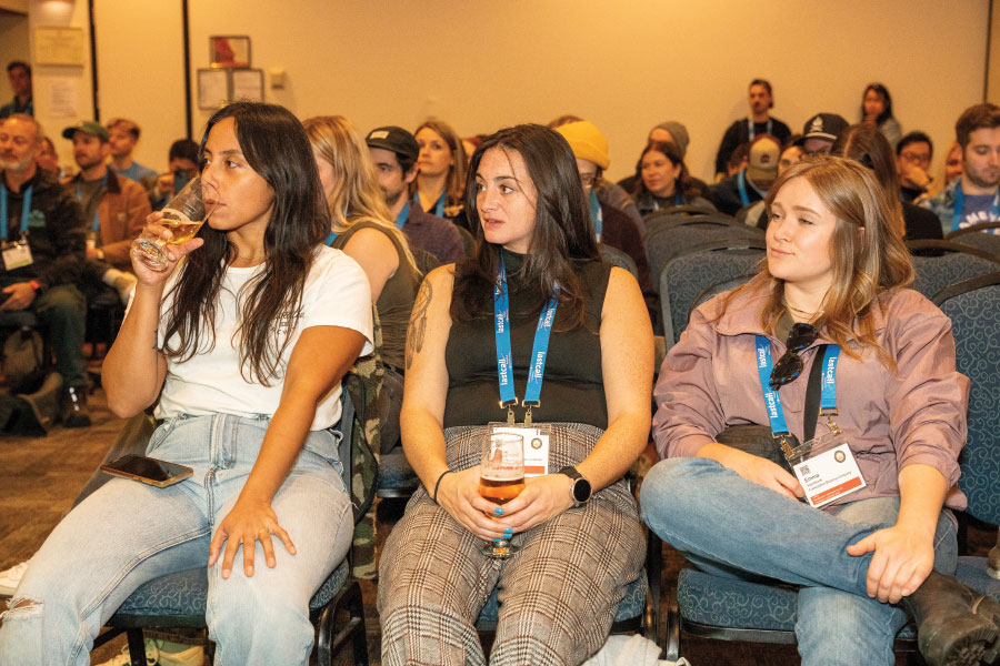 Attendees seated in chairs, some with glasses of beer in hand