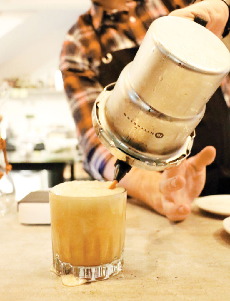 Man in plaid shirt injecting nitro in to beer